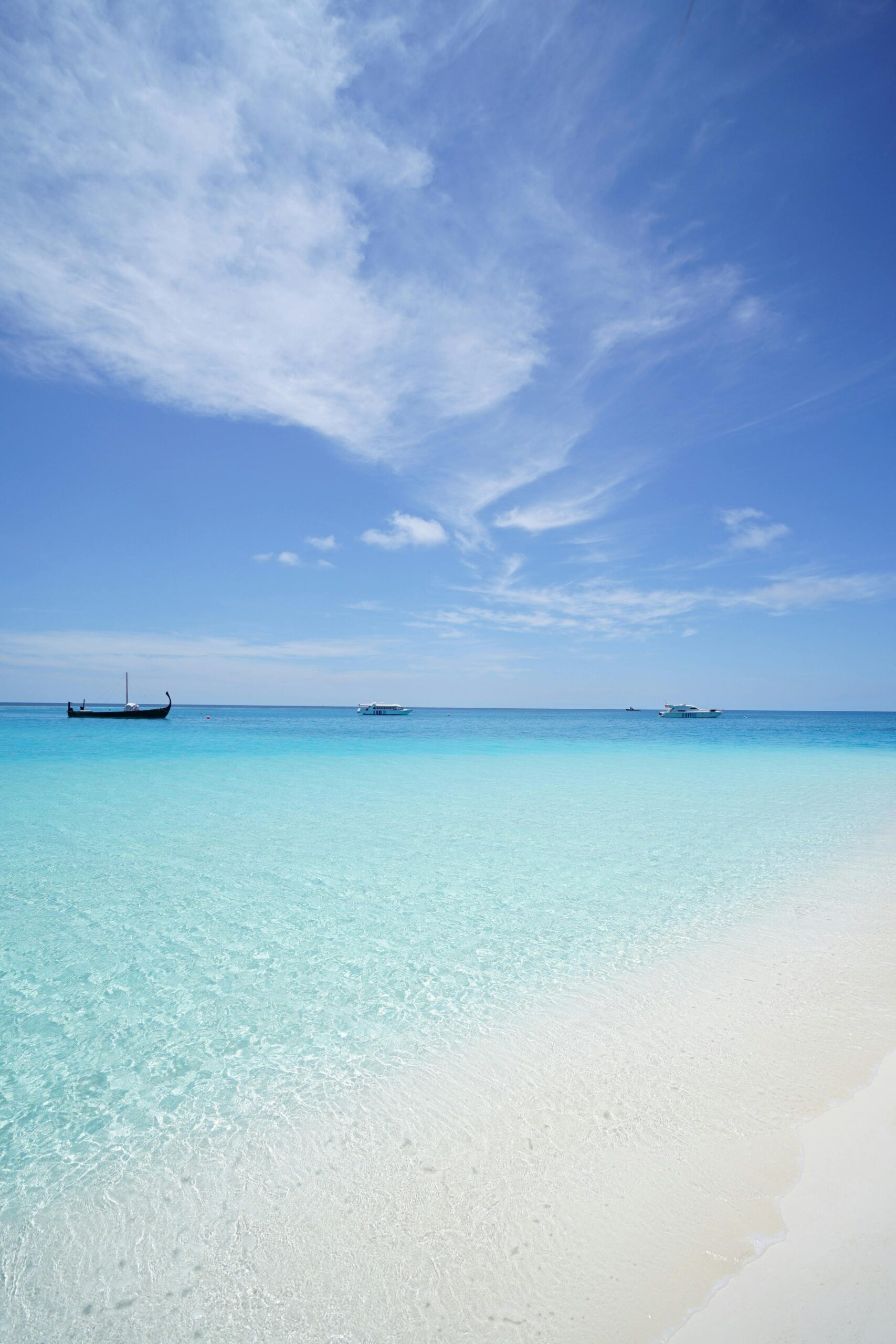 Peaceful beach scene with crystal clear waters and a deep blue sky, ideal for travel inspiration.